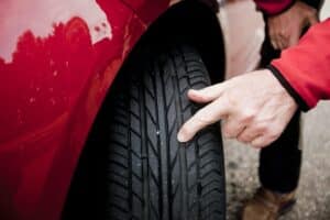 man checking car tyre inspection